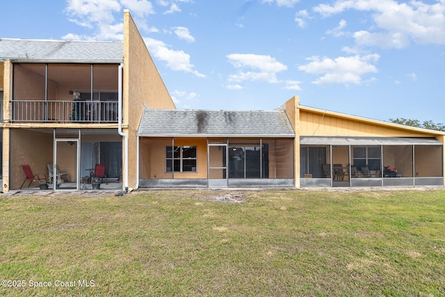 back of house featuring a yard, a patio area, and a sunroom