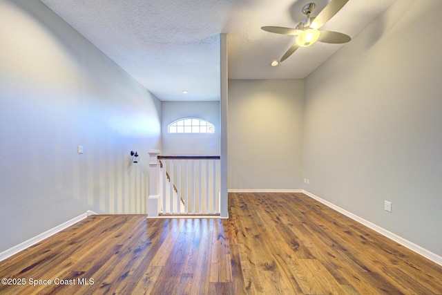 unfurnished room featuring wood-type flooring, a textured ceiling, and ceiling fan