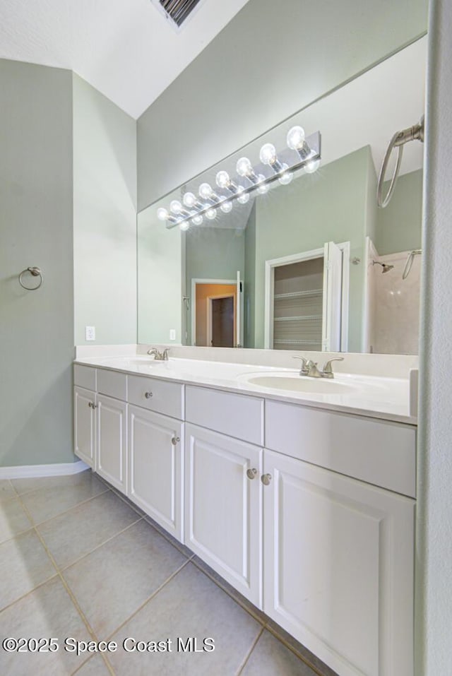 bathroom featuring tile patterned flooring, vanity, and walk in shower