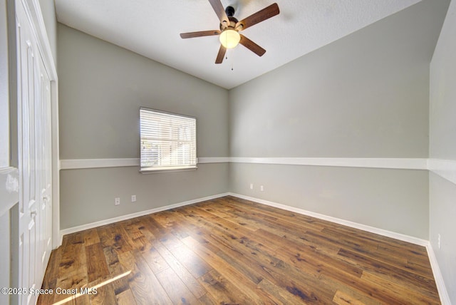 empty room with dark hardwood / wood-style floors and ceiling fan