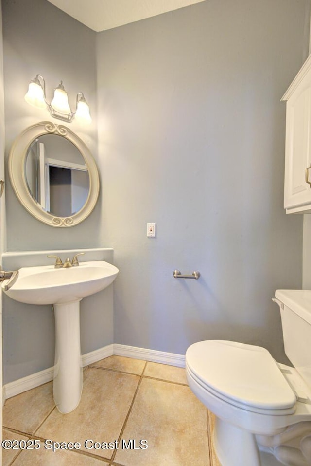 bathroom featuring tile patterned flooring, toilet, and sink