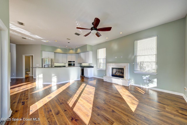 unfurnished living room with ceiling fan and dark hardwood / wood-style flooring