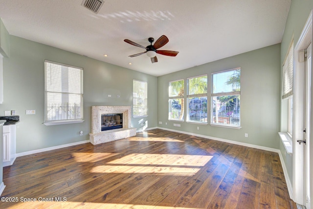 unfurnished living room featuring ceiling fan and dark hardwood / wood-style flooring