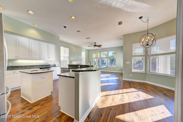 kitchen featuring pendant lighting, dark hardwood / wood-style flooring, white cabinetry, and a kitchen island