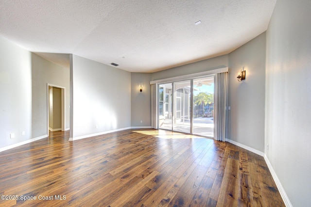 unfurnished room featuring dark hardwood / wood-style flooring and a textured ceiling