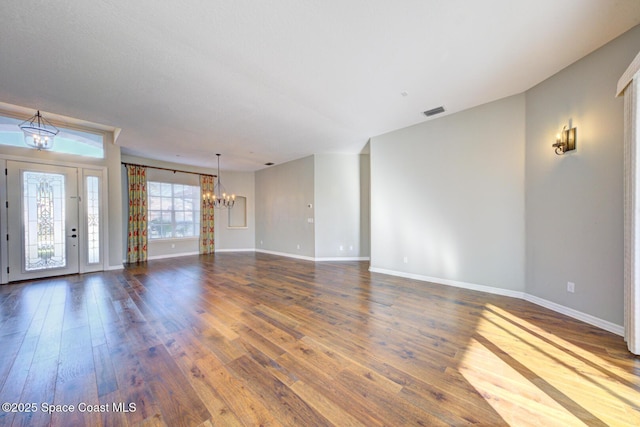 interior space featuring dark wood-type flooring and a notable chandelier