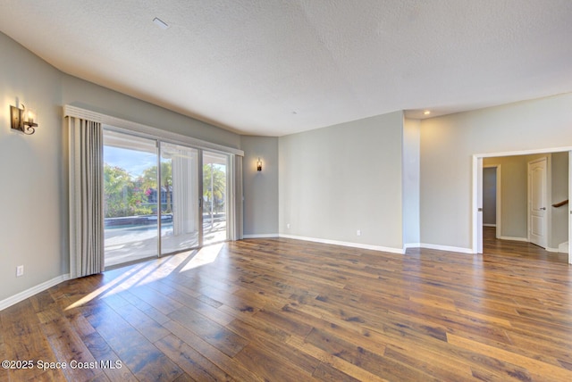 spare room with dark hardwood / wood-style flooring and a textured ceiling