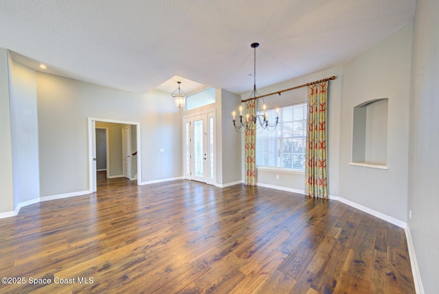 spare room featuring a textured ceiling, a chandelier, and dark hardwood / wood-style floors