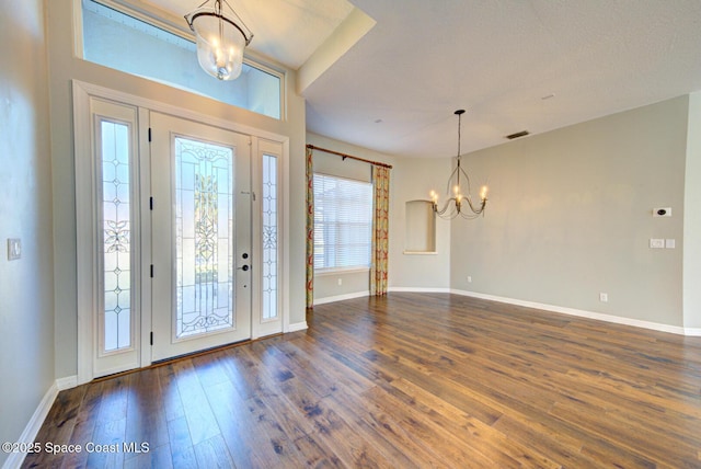 entryway featuring an inviting chandelier and dark wood-type flooring