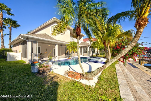 view of pool featuring a sunroom, ceiling fan, and a lawn