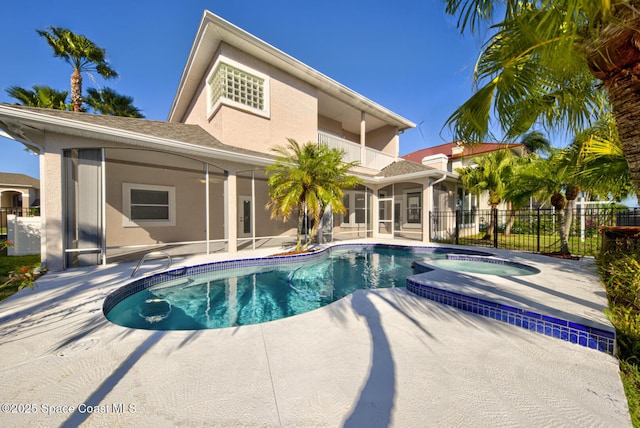 view of pool featuring a sunroom, an in ground hot tub, and a patio