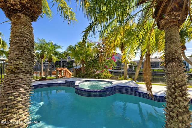 view of pool with a water view and an in ground hot tub