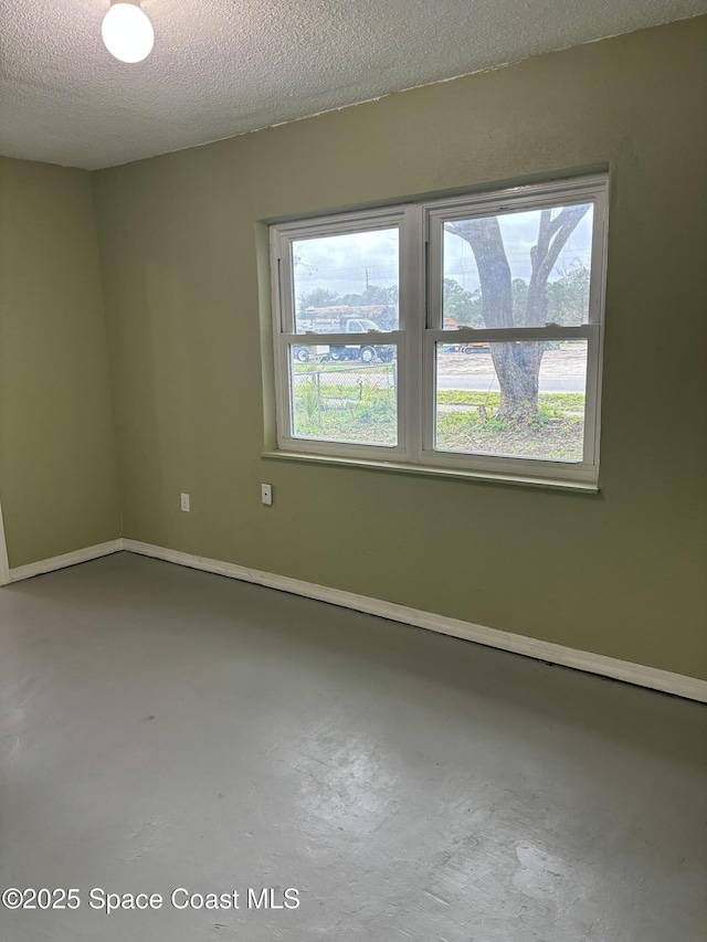 empty room with concrete flooring and a textured ceiling