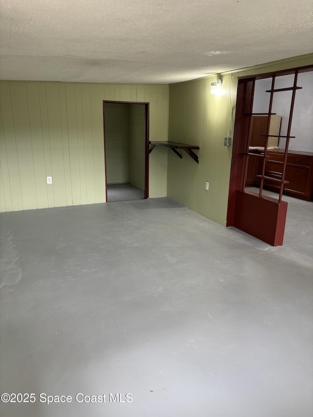 spare room with wood walls and a textured ceiling