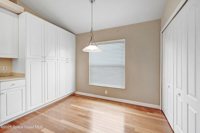 unfurnished dining area with light wood-type flooring