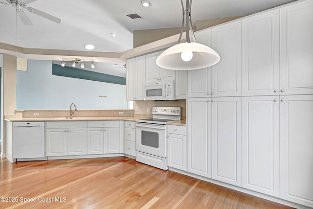 kitchen with pendant lighting, white cabinetry, sink, white appliances, and light hardwood / wood-style flooring