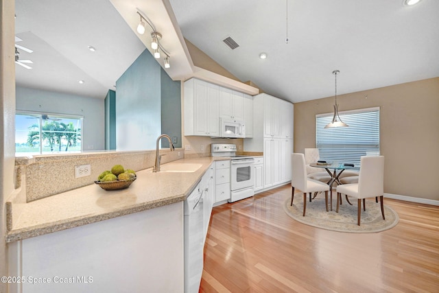 kitchen with lofted ceiling, sink, white cabinetry, pendant lighting, and white appliances