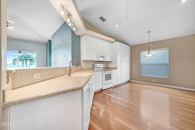 kitchen featuring vaulted ceiling, pendant lighting, sink, white cabinets, and white appliances