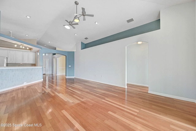 unfurnished living room featuring ceiling fan, lofted ceiling, and light hardwood / wood-style flooring