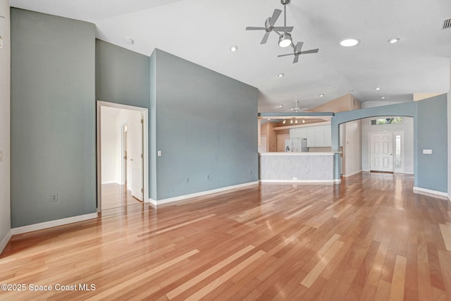 unfurnished living room with lofted ceiling, ceiling fan, and light hardwood / wood-style flooring