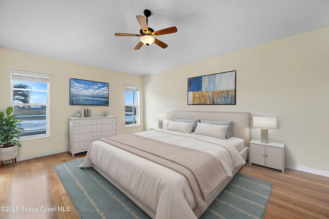 bedroom with lofted ceiling, light hardwood / wood-style flooring, and ceiling fan