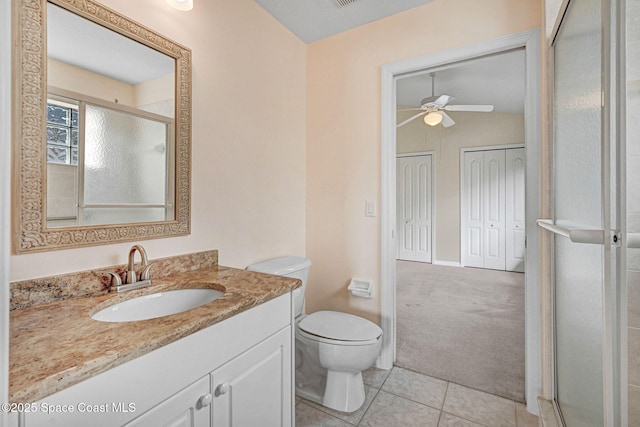 bathroom featuring toilet, a shower with shower door, vanity, ceiling fan, and tile patterned flooring