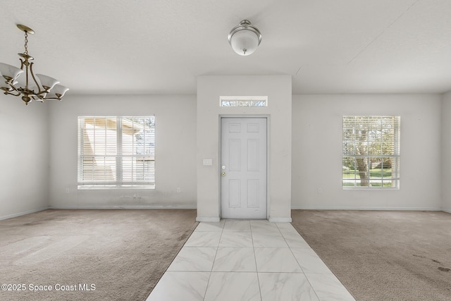 entryway featuring light colored carpet and a notable chandelier