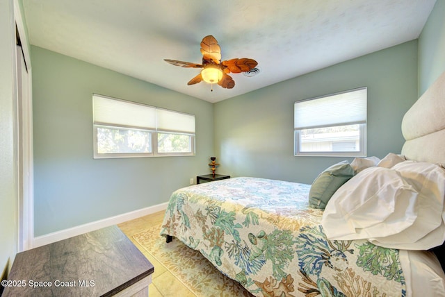 bedroom featuring multiple windows, ceiling fan, and a closet