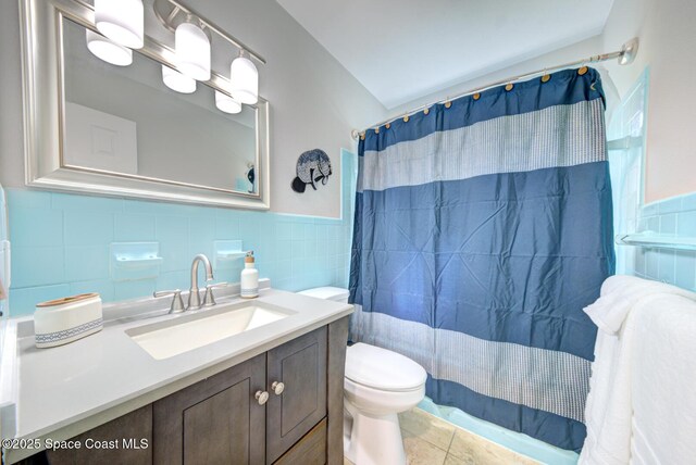 bathroom featuring tile patterned floors, vanity, tile walls, and toilet