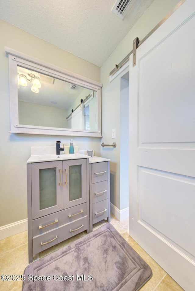 bathroom with tile patterned floors, vanity, and a textured ceiling