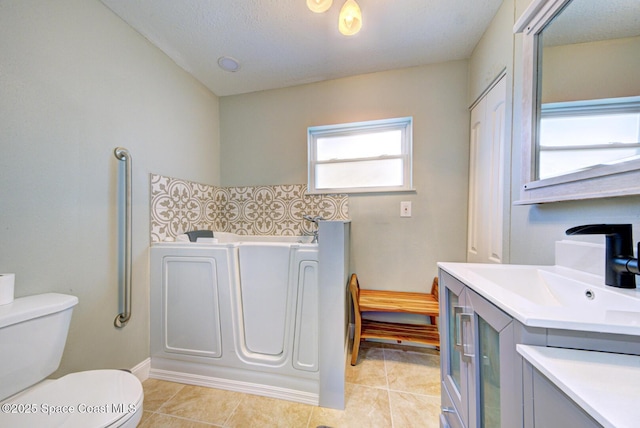 bathroom featuring toilet, vanity, tile patterned floors, and a bathing tub