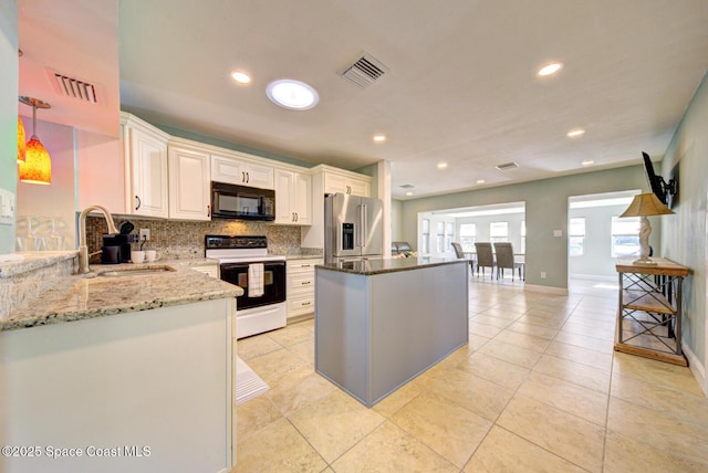 kitchen with light stone counters, high quality fridge, sink, electric stove, and hanging light fixtures