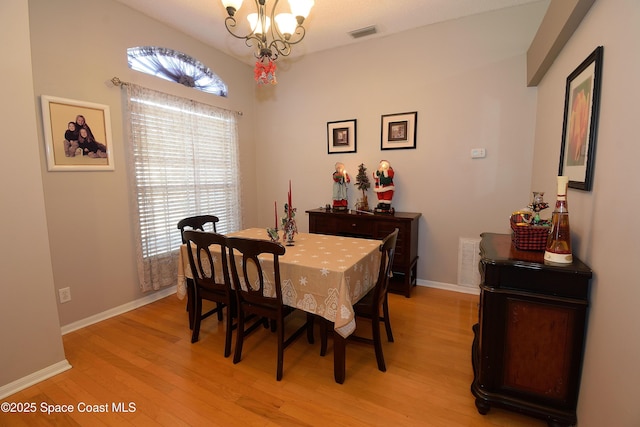 dining room with a notable chandelier and light hardwood / wood-style flooring