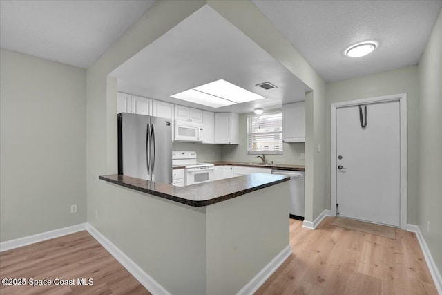 kitchen featuring white cabinets, kitchen peninsula, sink, and appliances with stainless steel finishes