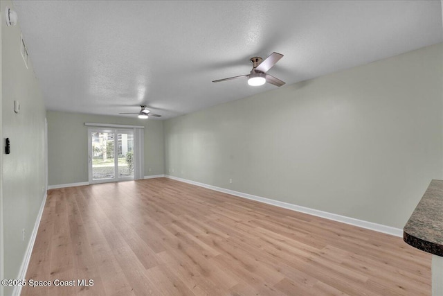 unfurnished room with light wood-type flooring, a textured ceiling, and ceiling fan