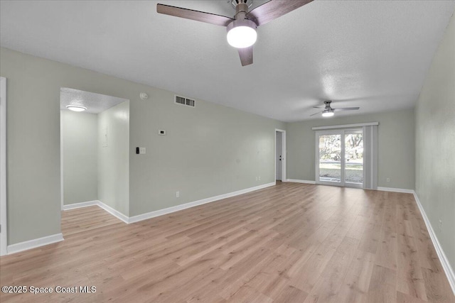 empty room with ceiling fan, light hardwood / wood-style flooring, and a textured ceiling