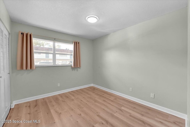 unfurnished room featuring light hardwood / wood-style floors and a textured ceiling