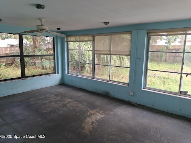 unfurnished sunroom with ceiling fan