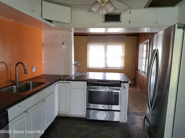 kitchen with sink, ceiling fan, appliances with stainless steel finishes, white cabinetry, and kitchen peninsula