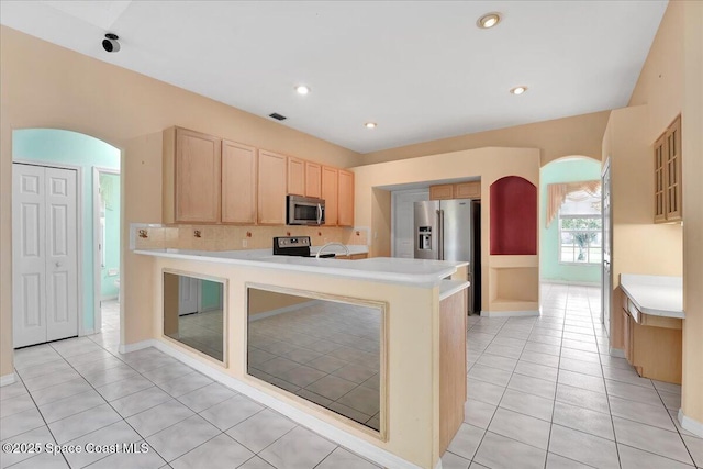 kitchen with kitchen peninsula, light brown cabinets, stainless steel appliances, and light tile patterned flooring