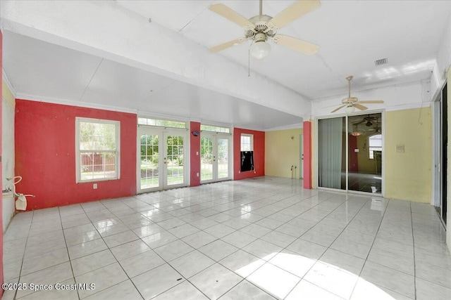 tiled empty room with ceiling fan and french doors