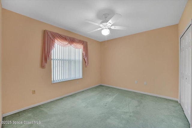 spare room featuring light carpet and ceiling fan