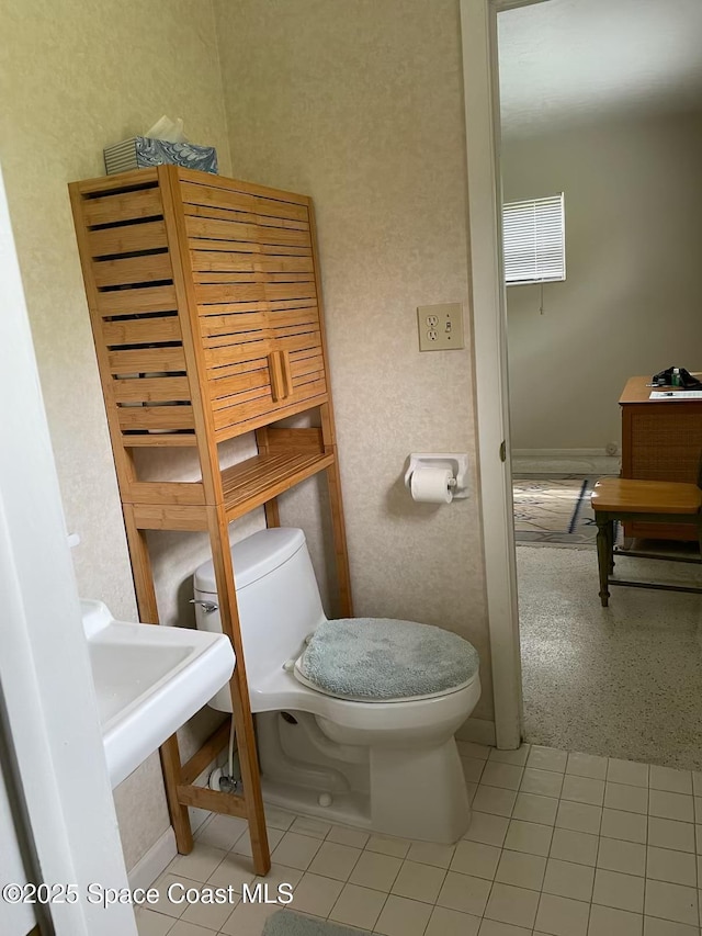 bathroom with toilet and tile patterned flooring