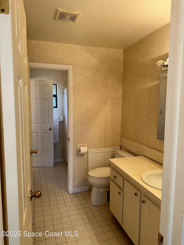 bathroom featuring tile patterned flooring, vanity, and toilet