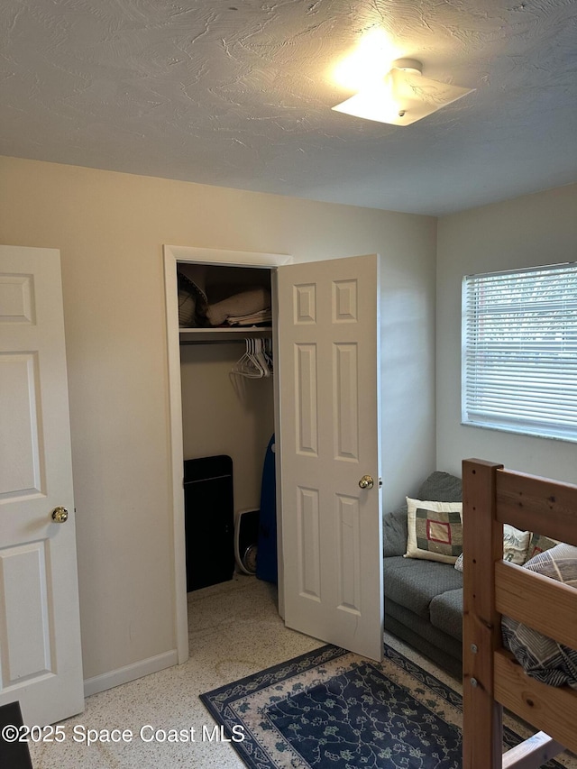 bedroom with a textured ceiling and a closet