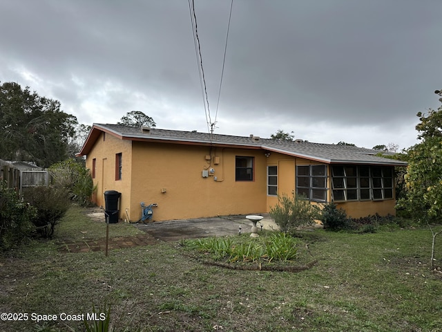 back of house featuring a sunroom and a yard