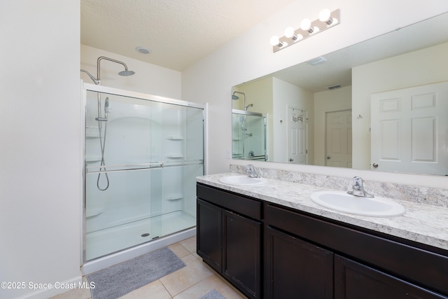 bathroom with tile patterned flooring, vanity, and a shower with door