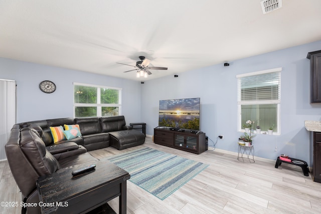 living room featuring ceiling fan and light hardwood / wood-style flooring