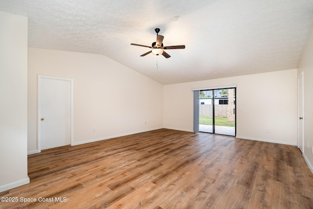 spare room featuring ceiling fan, wood-type flooring, lofted ceiling, and a textured ceiling