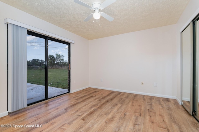 spare room with ceiling fan, light hardwood / wood-style floors, and a textured ceiling